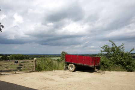 A red farm trailer in a farm yardの写真素材