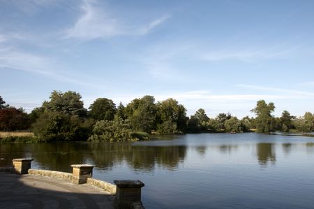 A lake in summer with trees in the backgroundの写真素材