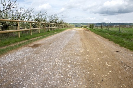 A road in the countryside with a wooden fenceの写真素材