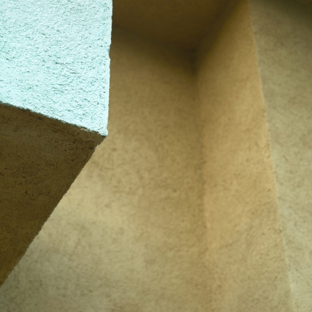 turquoise and orange stucco wall close upの写真素材