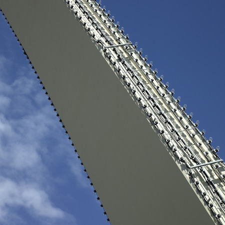 Arch with clear lightbulbs against blue sky
