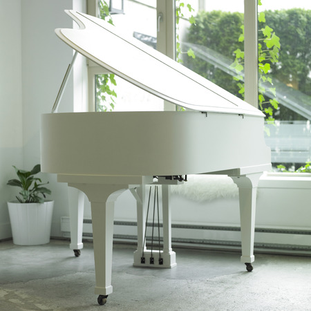 White baby grand piano in a white roomの写真素材