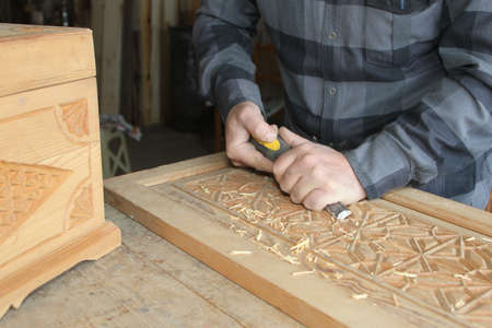 Carpenter working with woodworking tools at workshop, closeup