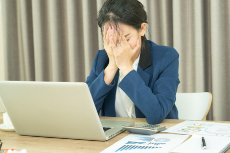 Stressed business woman working on a laptopの写真素材