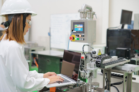 Woman software engineers developing automated robotic in production line, Industry
