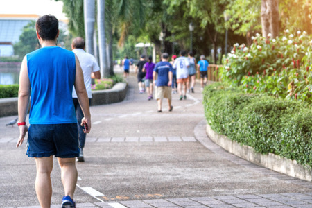 Blurry group of people exercise walking and jogging in the park in morning