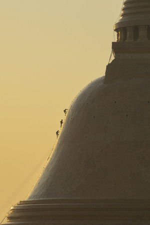Silhouette of a person climbing a pagoda.の写真素材