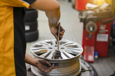 repair mechanic worker with light alloy car wheel disk rimの写真素材