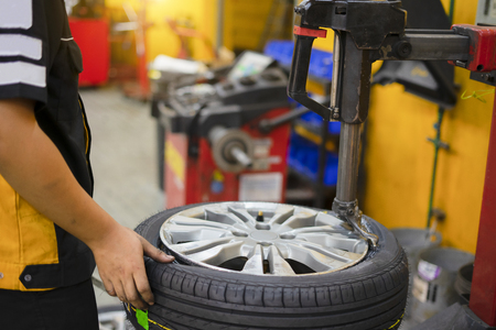 Mechanic removes car tire closeupの写真素材