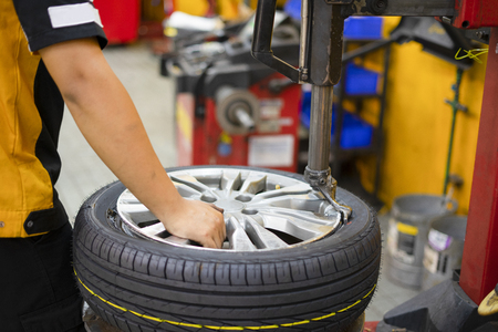 engineer balancing car wheel on balancer in workshopの写真素材