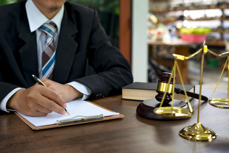 Male lawyer working with contract papers and wooden gavel on tabel in courtroom. justice and law ,attorney, court judge, concept.の写真素材