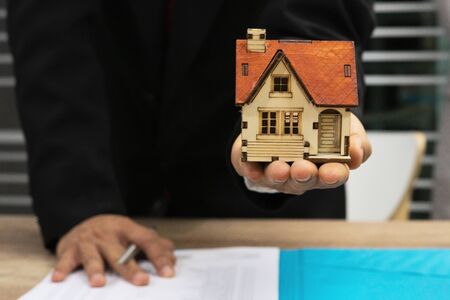 Real-estate agent sign for home contract property for sale in the office with buyerの写真素材