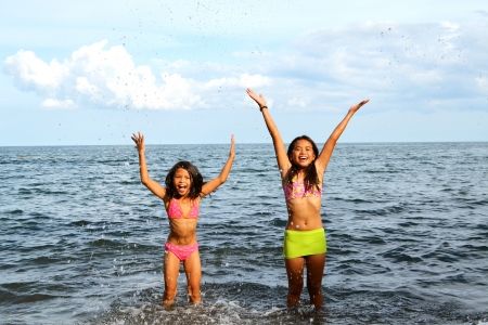 Cute Asian girls expressing their joy inside the waterの写真素材