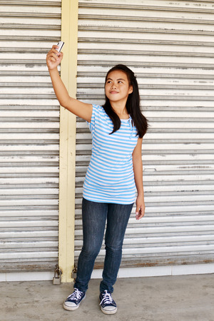 Young Asian teenager taking selfie in the streetの写真素材