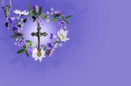 Rosary with illuminated crucifix surrounded by wild flower wreath on a purple background, religious card concept with copy spaceの写真素材