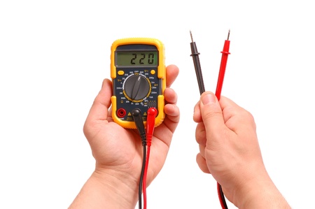 Hands with a digital multimeter on a white backgroundの写真素材