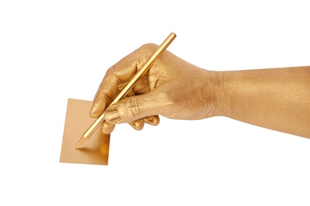 Man's golden hand writes on cut-away by a pencil. Isolated on the white の写真素材