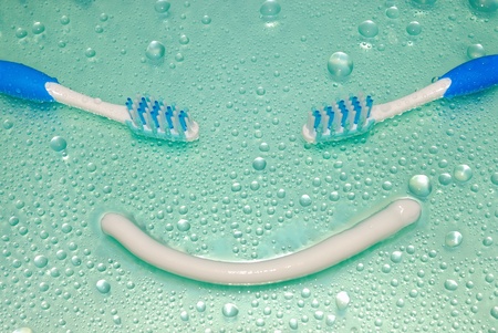 Toothbrushes and toothpaste in water drops