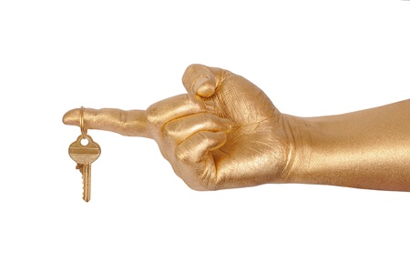 Man's golden hand with a key. Isolated on white の写真素材