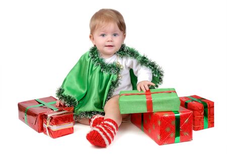 Little girl in Santa hat and green tree suit with New Year s gifts on white.の写真素材