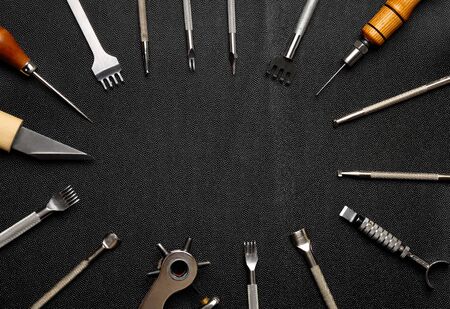 Leather crafting DIY tools lies on natural black leather.の写真素材