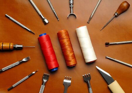 Leather crafting DIY tools lies on natural brown leather.の写真素材