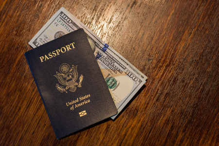 One blue American passport with US dollarsの写真素材
