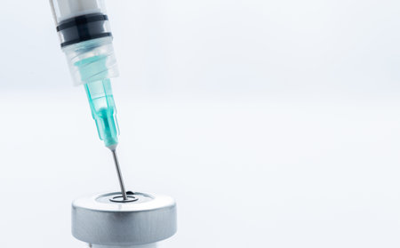 A hypodermic needle inside of a vial containing a vaccineの写真素材