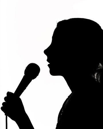 Singing yound girl with microphone on wihte background                    の写真素材