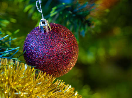 A Christmas ball with a background of artificial green branches of a Christmas tree.の写真素材