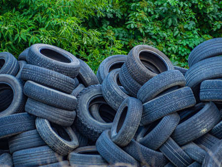 A pile of old used car tires on a parking lot in the countrysideの写真素材