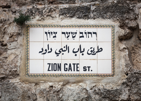 Tile street sign in Hebrew and English on a rock wall for the Zion Gate in the old city of Jerusalem.の写真素材