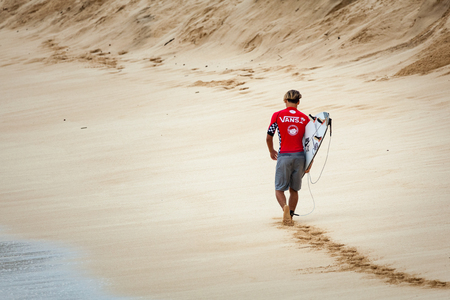SUNSET BEACH, HAWAII, USA - DECEMBER 2: Surfer walking the beach at the 2017 Vans World Cup of Surfing competition at Sunset Beach on Oahu's scenic North Shore. This is the second of three surfing competitions and Conner Coffin took first place.のeditorial素材