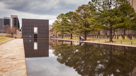 OKLAHOMA CITY, OKLAHOMA / USA - MARCH 31, 2018: People walking around and visiting the OKC Bombing Memorial and reflect in the shallow pool.のeditorial素材