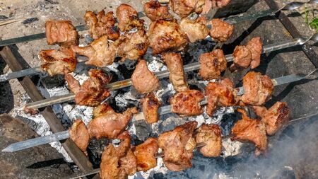 Grilled kebab cooking on metal skewer. Roasted meat cooked at barbecue. BBQ fresh beef meat chop slices. Traditional eastern dish, shish kebab. Summertime fun.Close-upの写真素材
