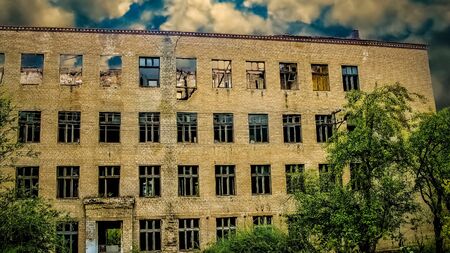 An old abandoned school without a roof and windows. View of the facade of the building. Ukraine.のeditorial素材