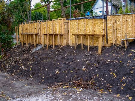 Wooden formwork for the construction of a concrete foundation, for a new fence. Construction of concrete floors, foundation formwork for a new fence.の写真素材