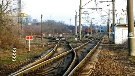 View on the railway track with old locomotives and railway depot, front view. Freight wagons carrying different loads. Heavy industry concept. Heavy industry. Cargo transit import export.の写真素材