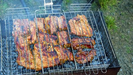 The process of cooking meat on the grill for barbecue, close up. Grilled meat, on the grid in the summer.  
の写真素材