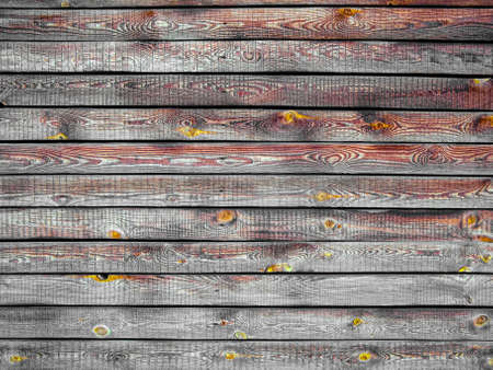 Background of brown wooden fence made of planks. The texture of an old rustic wooden fence made of flat processed boards. Wooden fence made of old boards with the inclusion of knots. Background design.の写真素材