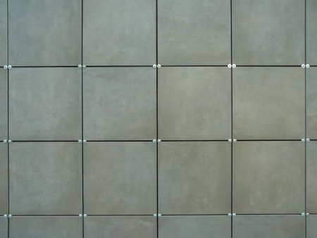 The wall is covered with green square tiles. Modern wall design. Exterior decoration of the walls of the house and external facades with siding.の写真素材
