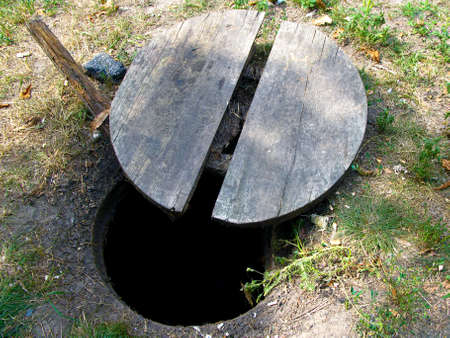 Top view of the dangerous open sewer manhole on the lawn, a danger to people who walk along the...