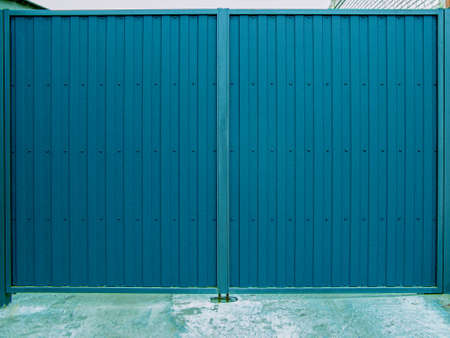 Protection against the penetration of thieves. The old metal door is locked with a padlock. Closed metal lock. Locked sheet metal doors. Home security concept.の写真素材