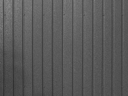 Corrugated sheet metal background. Modern technologies in construction. Metal tiles. Reliable, modern metal materials. Black and white photo.の写真素材