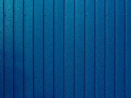 Background of blue corrugated metal sheet. Modern technologies in construction. Metal tiles. Reliable, modern metal materials.の写真素材