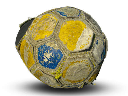 The soccer ball is very old and worn out on a white background. There is a shadow below. Cracked rough texture of soccer ball skin.の写真素材