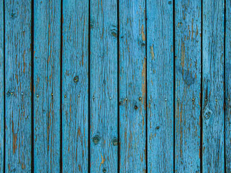Background of blue wooden fence made of planks. The texture of an old rustic wooden fence made of flat processed boards. Wooden fence made of old boards with the inclusion of knots. Background design.の写真素材