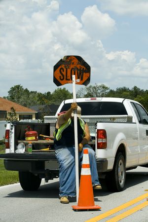 Man sitting on truck directing traffic to slow down