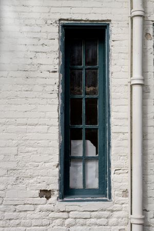 Old style wooden framed window on a brick wall