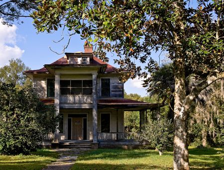 Weathered old house with front door boarded up and lockedの写真素材